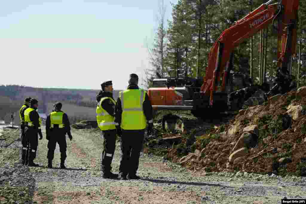 An excavator at work alongside Finnish border guards near the Pelkola border on April 14. The new border fence is due to be completed in 2026 and is expected to have a life span of around 50 years. &nbsp;