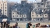 Палестинци ги носат своите работи по израелските напади врз станбените згради во градот Хамад, финансиран од Катар, во услови на тековен конфликт меѓу Израел и палестинската исламистичка група Хамас, во Кан Јунис во јужниот дел на Појасот Газа, 2 декември 2023 година.