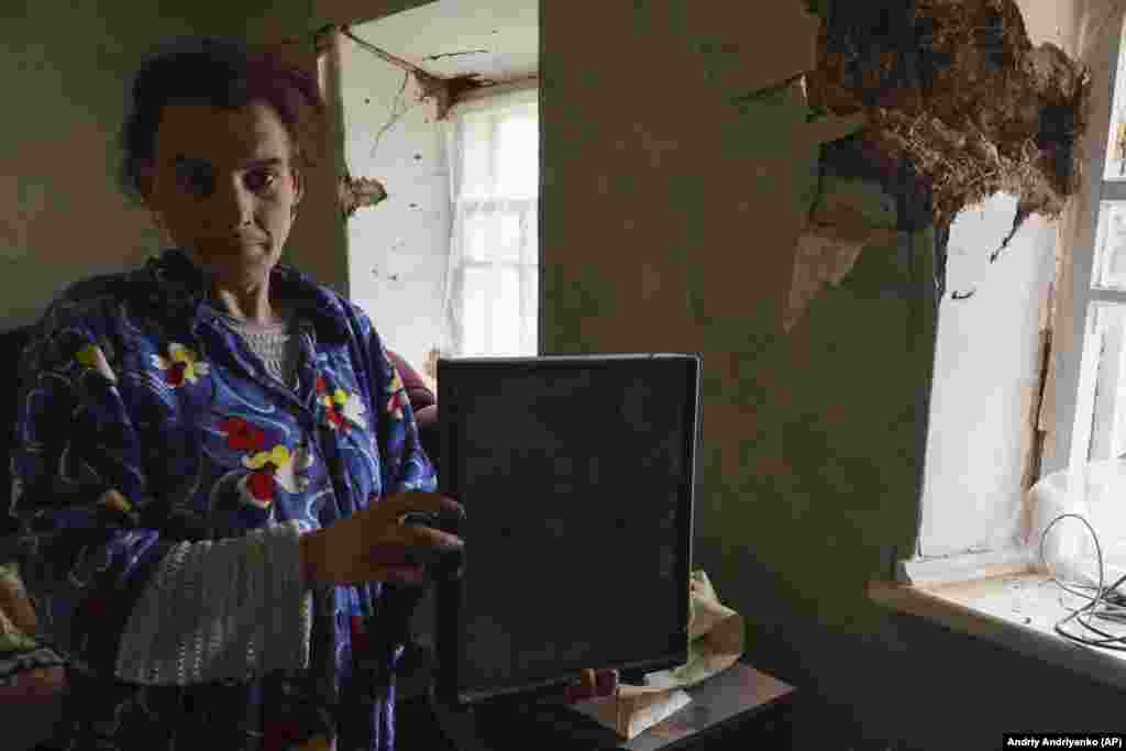 A woman holds an icon in her home that was damaged during the night following Russian shelling in Komyshevakha, Zaporizhzhya region.&nbsp;