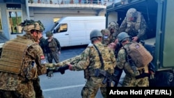 Pripadnici KFOR-a nose povređenog vojnika u sukobu sa lokalnim Srbima ispred zgrade Opštine u Zvečanu, Kosovo, 29. maja 2023.