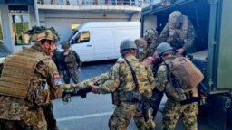 Pjesëtarë të KFOR-it duke e bartur me barelë një ushtar të lënduar gjatë përleshjeve me serbët lokalë, para ndërtesës komunale, në Zveçan, Kosovë, më 29 maj 2023.
