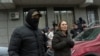 24.kg Director-General Asel Otorbaeva (right) is escorted by Kyrgyz security officers from the news outlet's offices in Bishkek on January 15. 