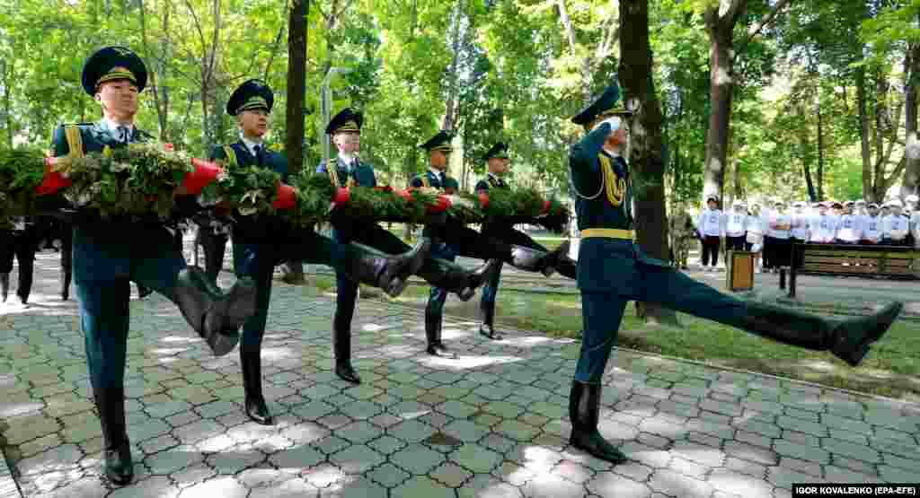 A kirgiz nemzeti gárda katonái koszorúkat visznek az elesett csernobili likvidátorok (a szennyezést felszámolni hivatott, életüket kockáztató egységek) emlékművénél tartott ünnepségen Biskekben