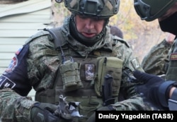 A Russian military investigator holds a piece of shrapnel in a suburb of Donetsk on October 24.