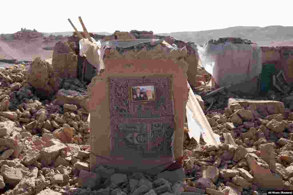 A family photograph hangs on the wall of a destroyed home following an earthquake in Chahak on October 11. The World Health Organization has put the total number of people affected at more than 11,000.