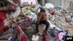 Реакція палестинця, який сидить на уламках зруйнованого будинку після ізраїльського військового удару по табору біженців, Рафах, Сектор Гази, 15 жовтня 2023 року