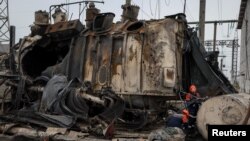 Работники "Укрэнерго" осматривают высоковольтный трансформатор, уничтоженный в ходе российского удара по ТЭЦ в Украине. Архивное фото