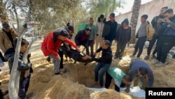 Хора погребват тела на палестинци, убити при израелски удар, в двора на болницата "Насър". Те не могат да стигнат до гробището поради израелската наземна операция в Хан Юнис в южната част на Ивицата Газа, 22 януари 2024 г.