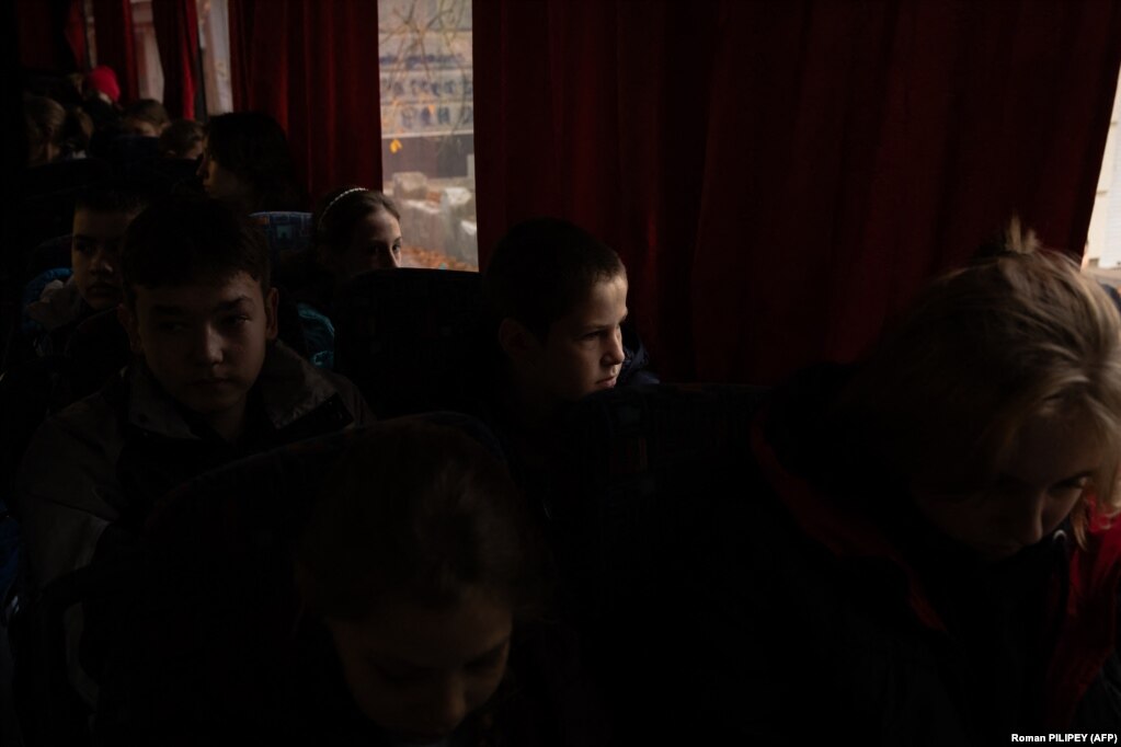 Con il rumore delle esplosioni in lontananza, i bambini aspettano sull'autobus di evacuazione prima della partenza.  "Il nostro compito è portare i bambini in un luogo sicuro per qualche mese", ha detto.  Lo ha detto il funzionario di Kherson Anton Yefanov.  "Abbiamo la sensazione che la situazione stia diventando sempre più pericolosa perché ci sono sempre più bombardamenti."