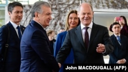 Канцлер Германии Олаф Шольц (справа) приветствует прибывшего с визитом в Берлин президента Узбекистана Шавката Мирзиёева. 2 мая 2023 года