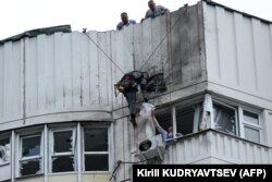 Specijalista pregleda oštećenu fasadu stambene zgrade nakon prijavljenog napada dronom u Moskvi 30. maja.