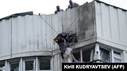 RUSIA -- Un specialist inspectează fațada deteriorată a unui bloc de apartamente cu mai multe etaje, după atacul cu drone de la Moscova, pe 30 mai 2023.