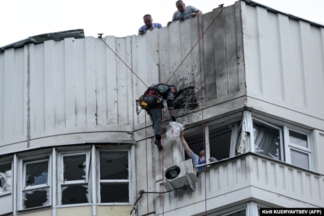 A specialist inspects the damaged facade of an apartment building after a reported drone attack in Moscow on May 30.