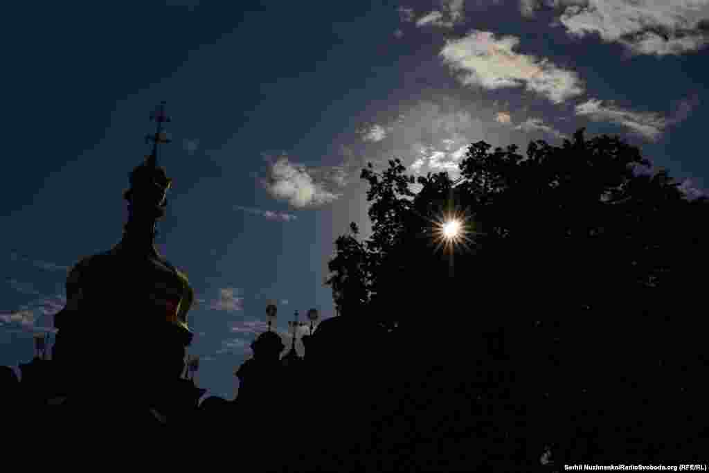 The Kyiv-Pechersk Lavra is silhouetted against the sky. It is a major pilgrimage site in Eastern Europe, attracting believers from all over the region.