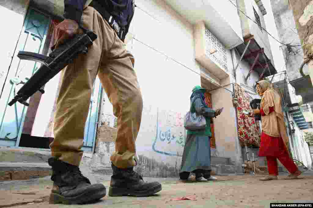 A worker of the Pakistan Bureau of Statistics, accompanied by an armed guard, collects data for the digital census in Karachi on March 1.