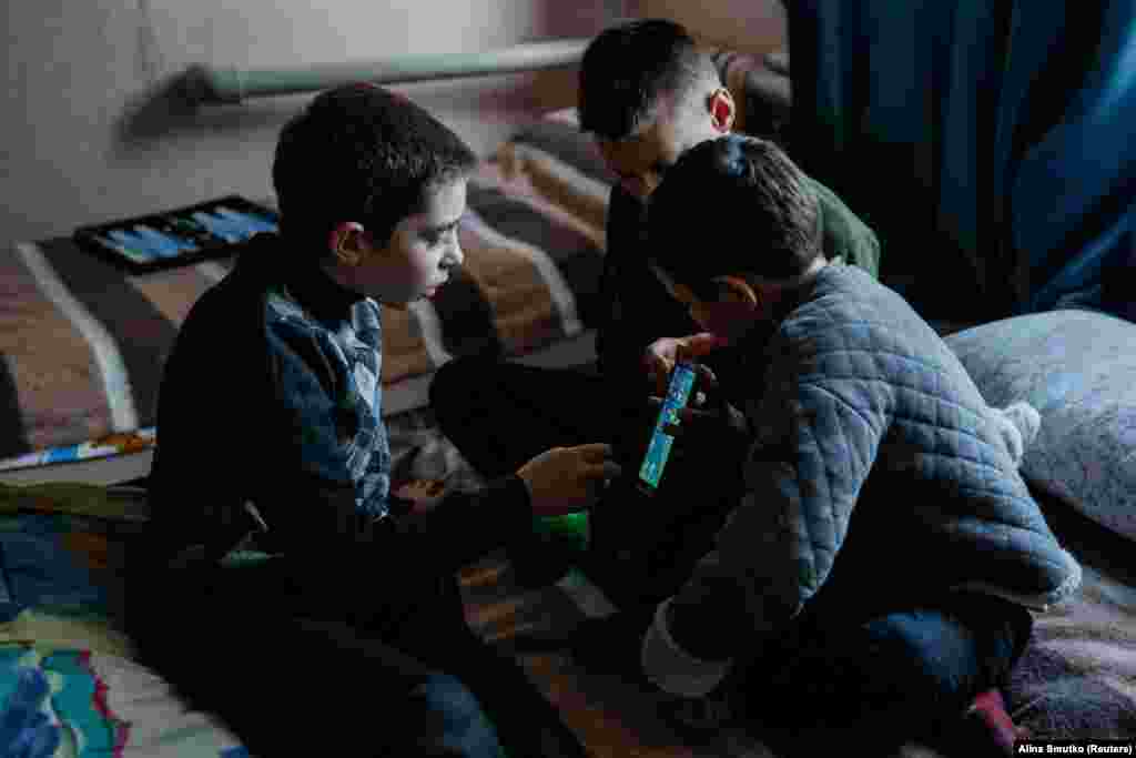 Denys plays with his new friends Ruslan and Artem, 11, at the shelter. &quot;This is my first time out of Toretsk,&quot; he confided to his new pals.