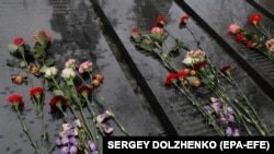 Цветы на плитах с именами ликвидаторов у памятника в честь погибших во время ликвидации последствий аварии на Чернобыльской АЭС по случаю ее 37-й годовщины, Киев, Украина, 26 апреля 2023 года