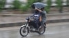 Two Pakistani men ride a motorbike during a heavy downpour in Karachi.