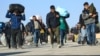 Afghan immigrants deported back from Iran carry their belongings at a registration center in the Islam Qala border town of the western Herat Province. (file photo)