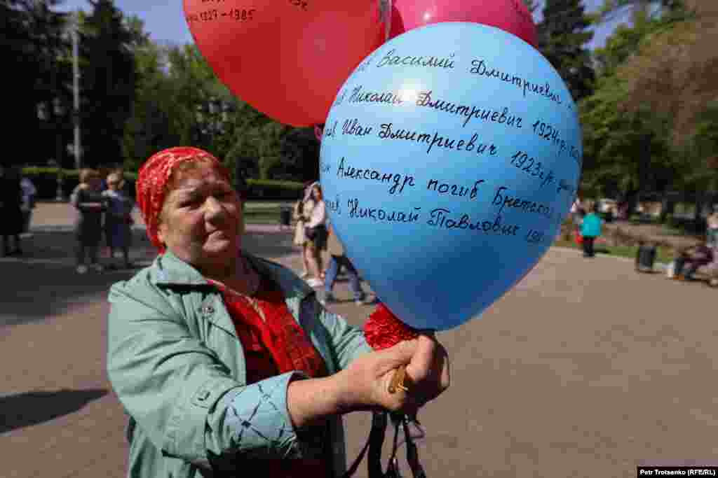 У церкви стояла женщина со связкой воздушных шаров, на которых она написала имена всех своих родственников, участвовавших во Второй мировой войне