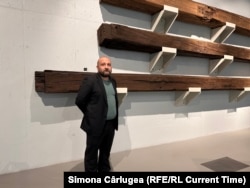 Lucian Rogoveanu, muzeograf la Muzeul de Artă Craiova, lângă bârnele de lemn recuperate din atelierul lui Brâncuși din Paris.