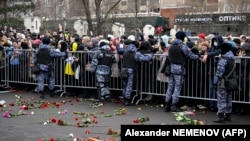 Почитувачите на Алексеј Навални фрлаат цвеќе пред автомобилот што го однесе телото на покојниот водач од црквата на гробиштата, Москва, 1 март 2024 година.