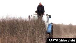 Володимир Сарган стоїть на тракторі ззовні і роздивляється, чи не стирчить із землі хвіст ракети