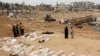 Луѓето се собираат во близина на телата наредени за идентификација откако беа ексхумирани од масовна гробница пронајдена во јужниот дел на Појасот Газа, 25 април 2024