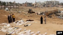 Луѓето се собираат во близина на телата наредени за идентификација откако беа ексхумирани од масовна гробница пронајдена во јужниот дел на Појасот Газа, 25 април 2024