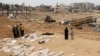 Ljudi se okupljaju u blizini tijela poredanih za identifikaciju nakon što su otkopana iz masovne grobnice pronađene u medicinskom kompleksu Nasser u južnom pojasu Gaze 25. aprila 2024. godine, 