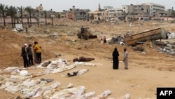 Ljudi se okupljaju u blizini tijela poredanih za identifikaciju nakon što su otkopana iz masovne grobnice pronađene u medicinskom kompleksu Nasser u južnom pojasu Gaze 25. aprila 2024. godine, 