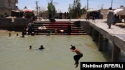 برخی کودکان در حال آببازی در یک حوض آب در هلمند (تصویر آرشیف)