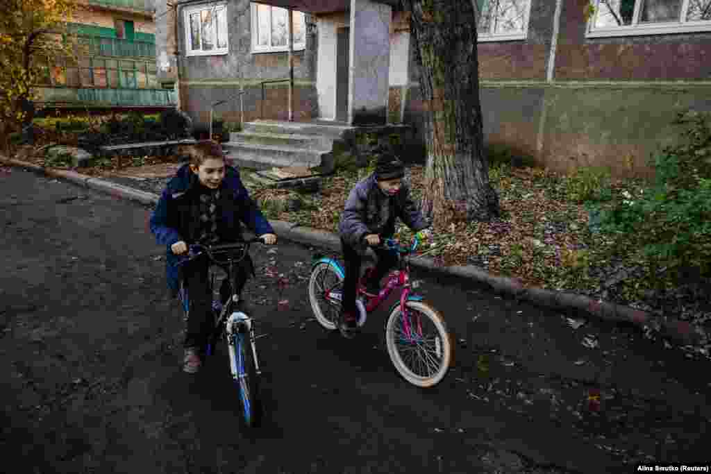 Denys and Ruslan ride bicycles. For Skachkova, the final straw was her son telling her that he was frightened by the constant shelling. &quot;So I decided to go,&quot; she said.