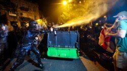 Riot police use pepper spray to disperse protesters during a rally against a controversial "'foreign agents' bill outside the parliament in Tbilisi on April 30.