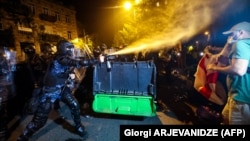 Riot police use pepper spray to disperse protesters during a rally against a controversial "'foreign agents' bill outside the parliament in Tbilisi on April 30.