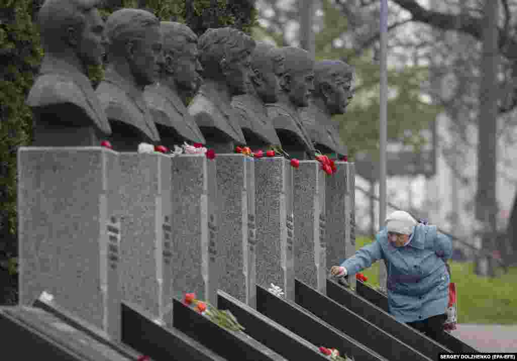 Інша жінка кладе квіти до меморіалу в Києві на честь тих, хто загинув, намагаючись прибрати радіоактивні уламки на ЧАЕС. Київ, 26 квітня 2023 року