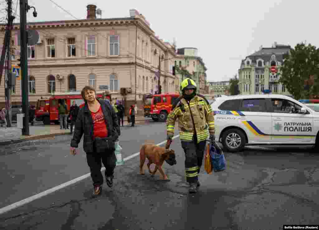 Un membru al echipelor de salvare cu un câine. Moscova respinge acuzațiile că ar lovi deliberat ținte civile, dar mulți au murit deja în atacuri asupra unor centre rezidențiale, instalații portuare, infrastructură energetică sau depozite de cereale.