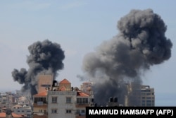 Клубы дыма над жилыми домами после авиаударов Израиля по городу Газа, 7 октября 2023 года