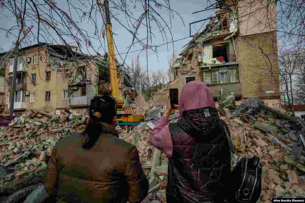 Місцеві жителі фотографують наслідки ракетного удару по житловому будинку в місті Селидове на сході України. Місцева влада повідомила, що в результаті російської атаки загинули щонайменше двоє людей, у тому числі 85-річна жінка.&nbsp;15 листопада 2023 року
