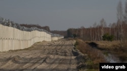 Бетонна стіна з колючим дротом на кордоні з Білоруссю