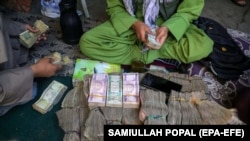 An Afghan currency dealer sorts Afghani bills at a currency market in Kabul. (file photo)
