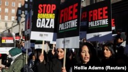 Učesnici "Nacionalnog marša za Palestinu" u centru Londona nose plakate kojima pozivaju na prestanak bombardovanja Gaze, 11. novembar 2023.