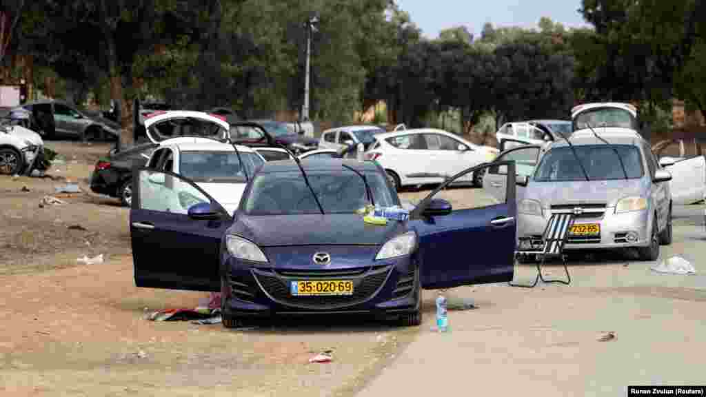 Hátrahagyott autók a határ menti zenei fesztivál parkolójában, ahol a Hamász fegyveresei fiatal fesztiválozókra támadtak.&nbsp;Kfar Aza egyike azon kibucoknak, kis mezőgazdasági enklávéknak, amelyek a Hamász szombati szárazföldi támadásának fő csapásirányát viselték. Számos kibuc és város volt a célpont. Beriben például több mint száz holttestet találtak. Lelőtték vagy túszul ejtették a külterületén, a sivatagban tartott zenei fesztiválon részt vevőket is