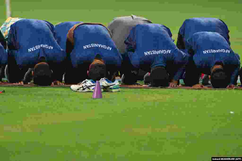 Afghan players offer prayers during a practice session on the eve of their 2023 Men&#39;s Cricket World Cup game against Australia.