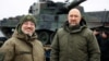 Ukrainian Prime Minister Denys Shmyhal (right) and Defense Minister Oleksiy Reznikov stand next to the first Leopard 2 tanks delivered from Poland on February 24.