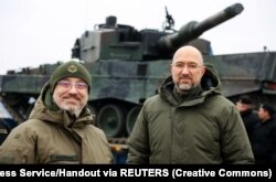Прем’єр-міністр України Денис Шмигаль (праворуч) і міністр оборони Олексій Резніков біля перших танків Leopard 2, доставлених із Польщі, 24 лютого 2023 року