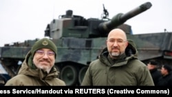 Denisz Smihal ukrán kormányfő és Olekszij Reznyikov védelmi miniszter az első leszállított Leopard 2-es harckocsikkal 2023. február 24-én