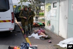 Ізраїльські солдати біля тіл цивільних, убити бойовиками «Хамасу». Сдерот, Ізраїль. 7 жовтня 2023 року