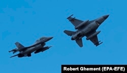 Румынские пилоты на самолетах F16 Falcon во время демонстрационного полета после церемонии открытия Европейского учебного центра F-16. Румыния, 13 ноября 2023 года
