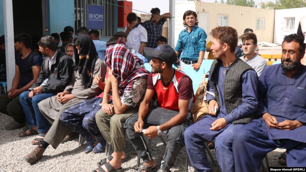 Afghans expelled from Iran wait outside the office of the International Organization of Migration in the western Afghan province of Herat. (file photo)